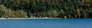 Lakefront properties along a Vermont shoreline surrounded by fall foliage.