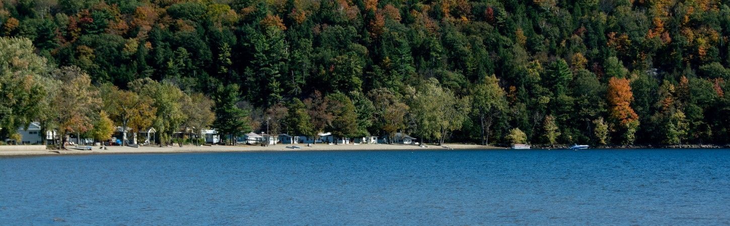 Lakefront properties along a Vermont shoreline surrounded by fall foliage.